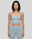 CoreLine Sports Bra in haze blue, mid body front view styled for activewear