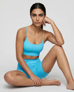 CoreLine Sports Bra in lake blue, styled on model sitting down