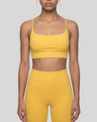 CoreLine Studio Sports Bra in yellow, mid body front view