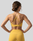 CoreLine Studio Sports Bra in yellow, back view styled on model with strappy detail