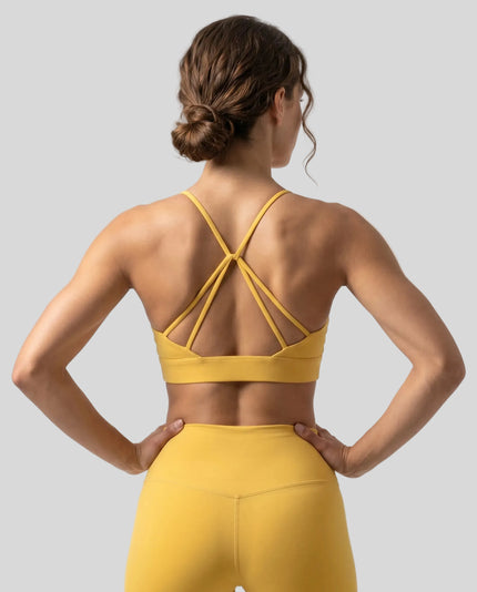 CoreLine Studio Sports Bra in yellow, back view styled on model with strappy detail