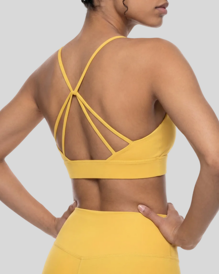 CoreLine Studio Sports Bra in yellow, upper body angled back view
