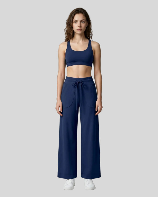 Front view of woman wearing Navy Blue CoreLine Yoga Pants with a matching color sports bra.