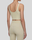 Back angle view of model wearing CoreLine Yoga Sports Bra in Pale Khaki