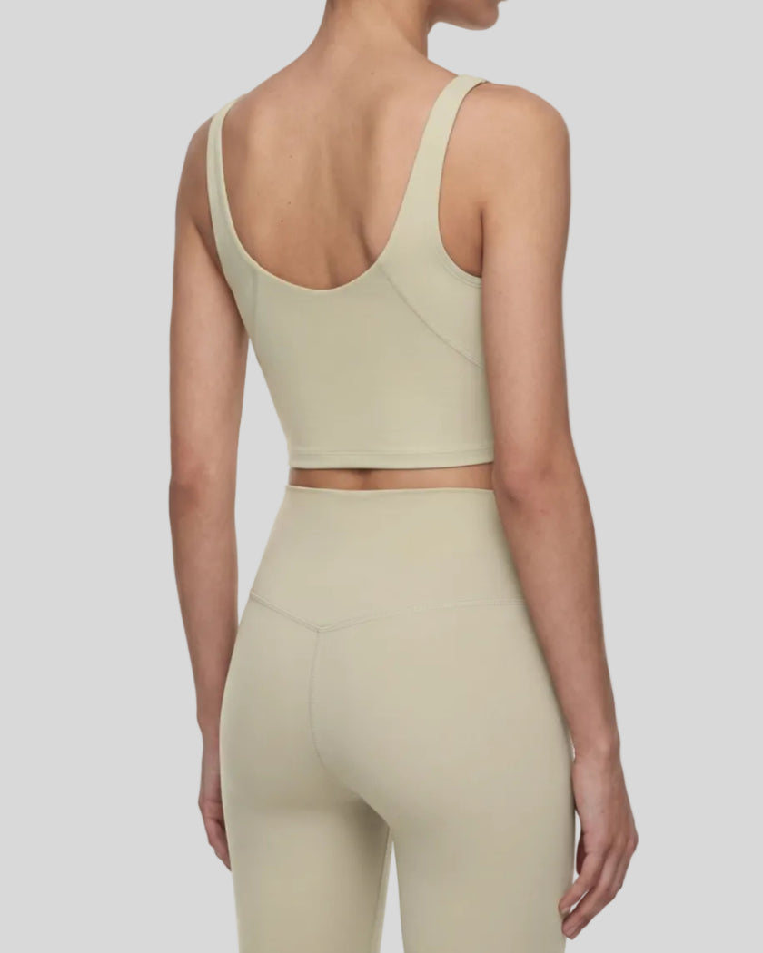 Back angle view of model wearing CoreLine Yoga Sports Bra in Pale Khaki