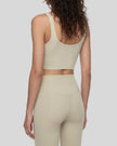 Model wearing CoreLine Yoga Sports Bra in Pale Khaki angled back view