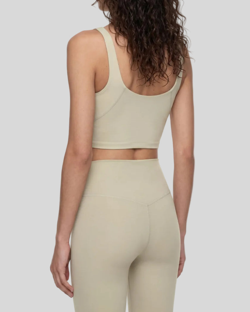 Model wearing CoreLine Yoga Sports Bra in Pale Khaki angled back view