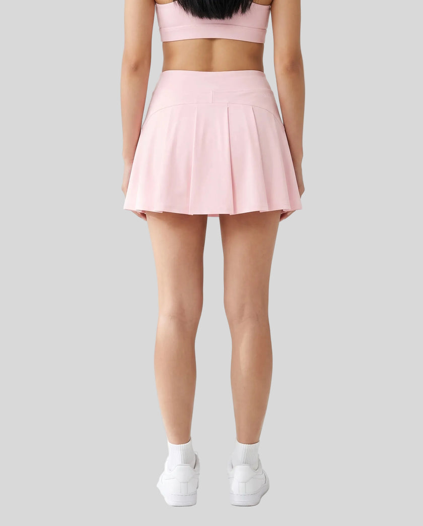 Back view of a model wearing the CourtClub A-Line Skirt in Light Pink