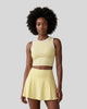 Mid body view of a model wearing the CourtClub A-Line Skirt in Yellow paired with TrackLine Rally Tank Top in Yellow