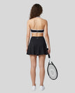 Back view of a model wearing the CourtClub Color Block A-Line Skirt in Black