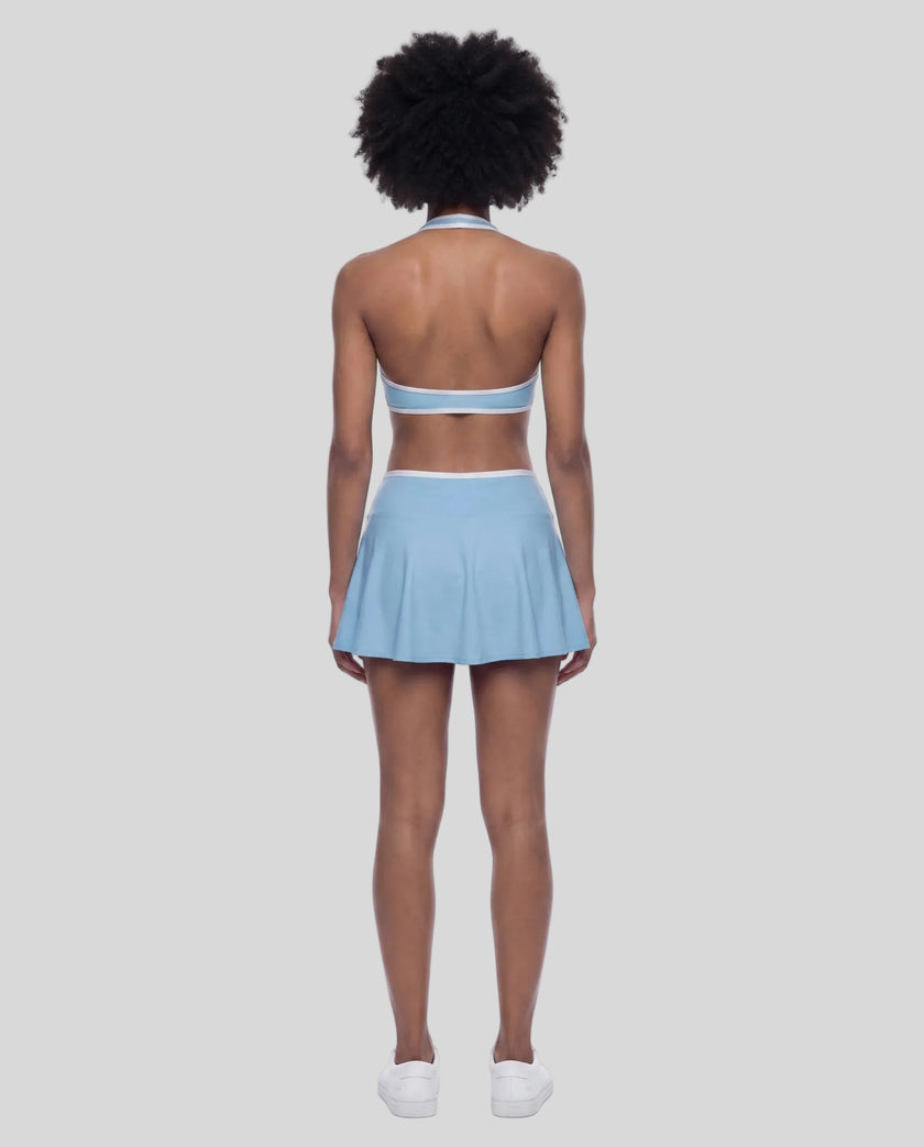 Back view of a model wearing the CourtClub Color Block A-Line Skirt in Sky Blue