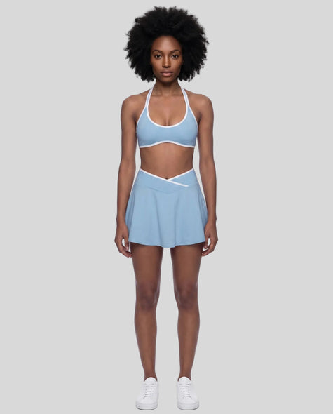 Model wearing the CourtClub Color Block A-Line Skirt in Sky Blue, lower body front view