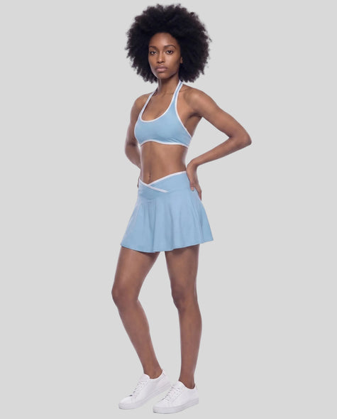 Left-angle view of a model wearing the CourtClub Color Block A-Line Skirt in Sky Blue