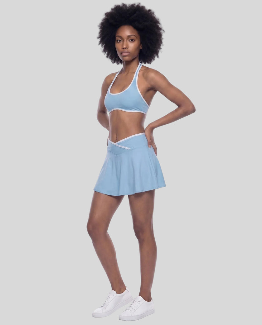 Left-angle view of a model wearing the CourtClub Color Block A-Line Skirt in Sky Blue