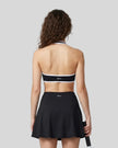 Back view of a model wearing the CourtClub Color Block Halter Sports Bra in Black