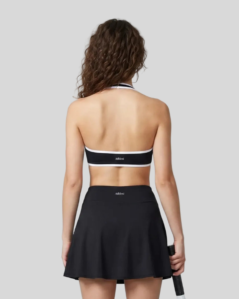 Back view of a model wearing the CourtClub Color Block Halter Sports Bra in Black