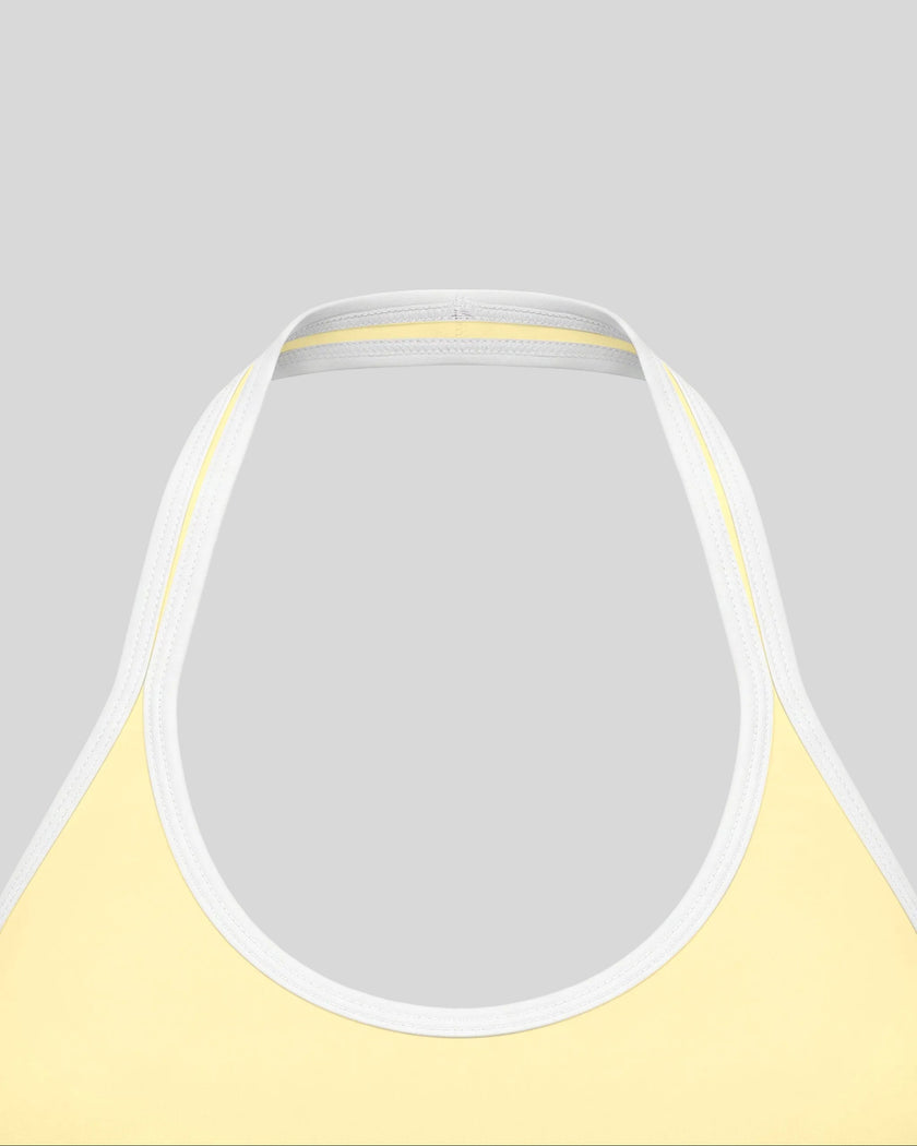Close-up of the halter neckline and color block trim on the CourtClub Color Block Halter Sports Bra in Light Yellow