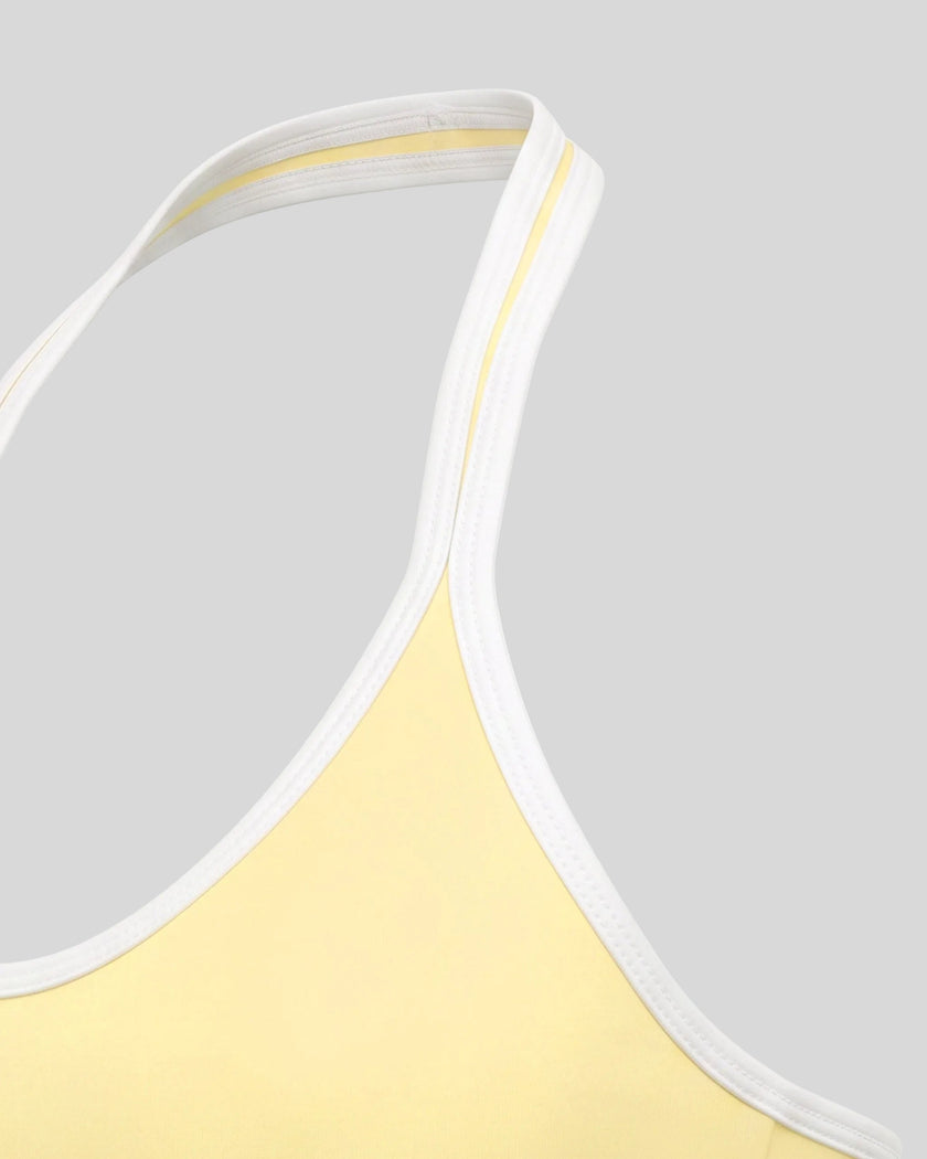 Side view highlighting the sleek profile and supportive fit of the CourtClub Color Block Halter Sports Bra in Light Yellow