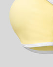 Close-up of the smooth underbust band and color block trim on the CourtClub Color Block Halter Sports Bra in Light Yellow