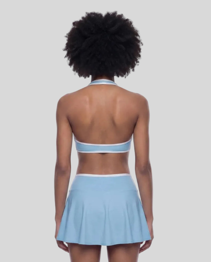 Back view of a model wearing the CourtClub Color Block Halter Sports Bra in Sky Blue
