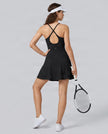 Woman wearing CourtClub Crossback Dress in Black, mid-body back view highlighting the crisscross straps and open keyhole detail