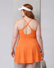 Woman wearing CourtClub Crossback Dress in Orange, mid-body back view highlighting the fitted bodice