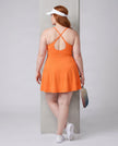 Woman wearing CourtClub Crossback Dress in Orange, mid-body back view highlighting the crisscross straps and open keyhole detail
