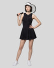 Woman wearing the Athlesi CourtClub Full-Zip Dress in Black, full-body front view styled for court and club.