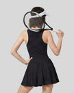 Woman wearing the Athlesi CourtClub Full-Zip Dress in Black, closer back view highlighting the sleeveless fit and waistline.