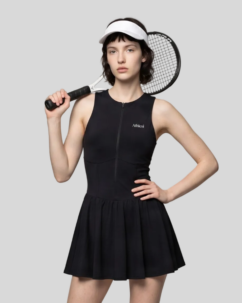 Woman wearing the Athlesi CourtClub Full-Zip Dress in Black, closer front view highlighting the neckline, zipper and fitted bodice.