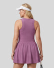 Woman wearing the Athlesi CourtClub Full-Zip Dress in Deep Purple, closer back view highlighting the sleeveless fit and waistline.