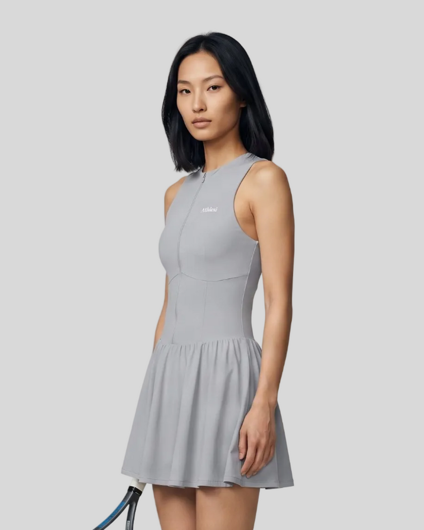Woman wearing the Athlesi CourtClub Full-Zip Dress in Gray, closer front angle view highlighting the neckline, zipper and fitted bodice.