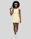 Woman wearing the Athlesi CourtClub Full-Zip Dress in Light Yellow, full-body front view styled for court and club.