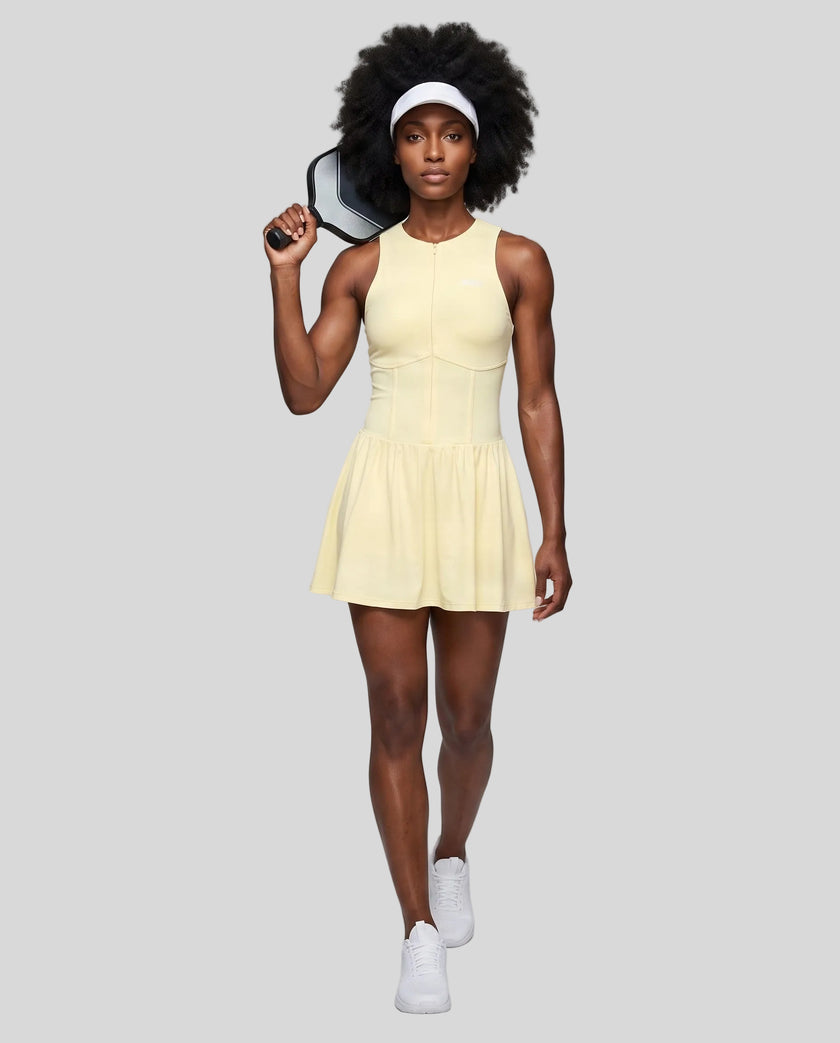 Woman wearing the Athlesi CourtClub Full-Zip Dress in Light Yellow, full-body front view styled for court and club.