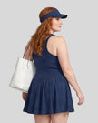 Woman wearing the Athlesi CourtClub Full-Zip Dress in Navy Blue, closer back view highlighting the sleeveless fit and waistline.