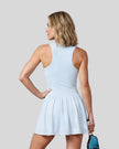 Woman wearing the Athlesi CourtClub Full-Zip Dress in Water Blue, closer back view highlighting the sleeveless fit and waistline.