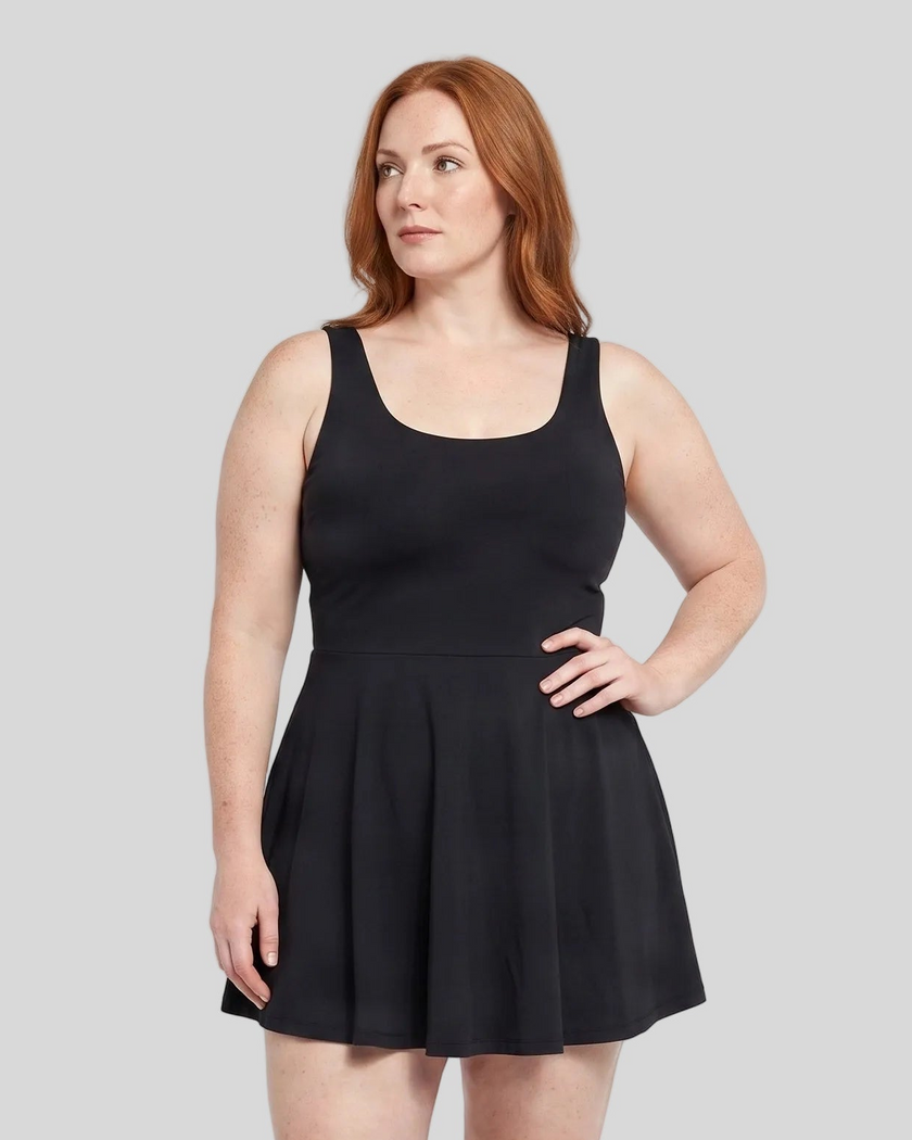 Woman wearing Athlesi CourtClub Open-Back Tennis Dress in Black mid-body front view showing scoop neckline and flared silhouette