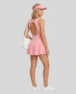 Woman wearing Athlesi CourtClub Open-Back Tennis Dress in Pink full-body back view showing open-back design
