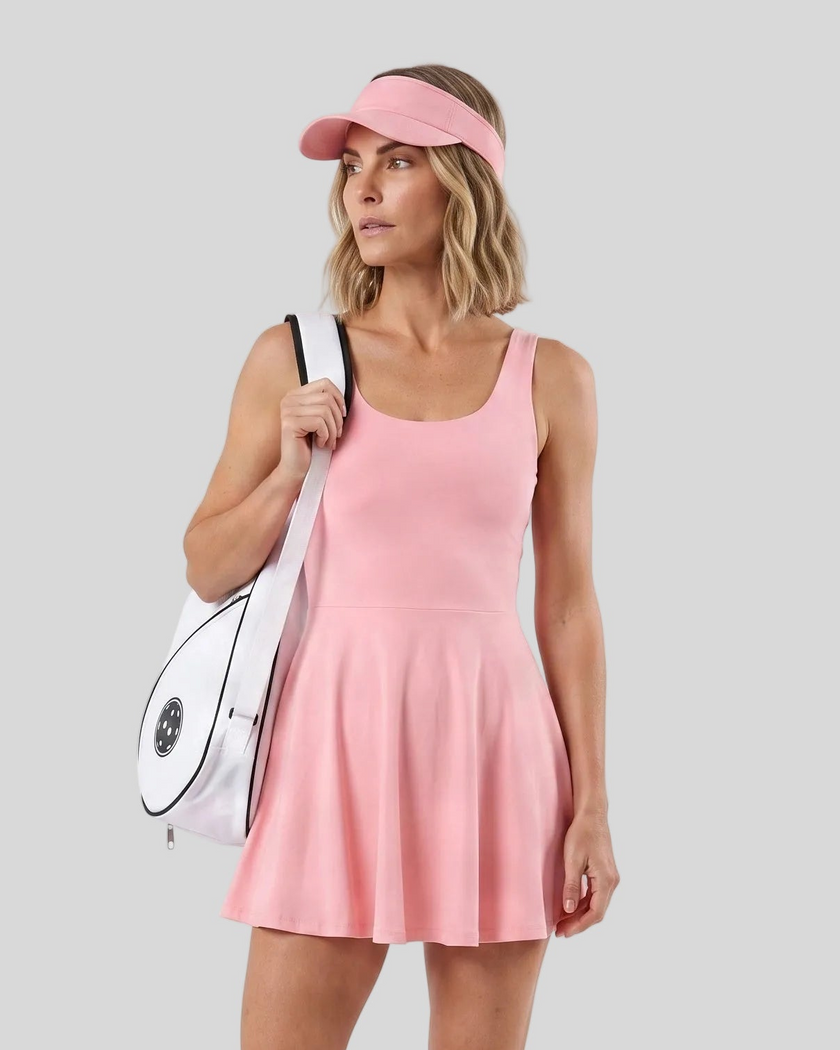 Woman wearing Athlesi CourtClub Open-Back Tennis Dress in Pink mid-body front view showing scoop neckline and flared silhouette