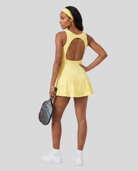 Woman wearing Athlesi CourtClub Open-Back Tennis Dress in Yellow full-body back view showing open-back design