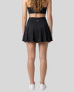Back view of a model wearing the CourtClub Pleated Skirt in Black