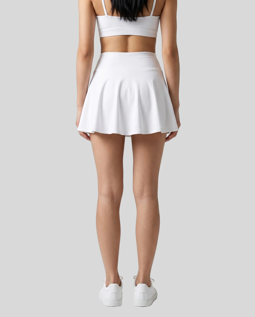 Back view of a model wearing the CourtClub Pleated Skirt in White