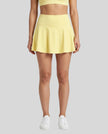 Model wearing the CourtClub Pleated Skirt in Yellow viewed from the front