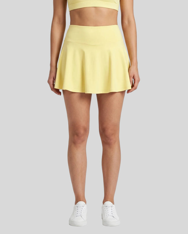 Model wearing the CourtClub Pleated Skirt in Yellow viewed from the front