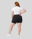 Woman wearing Athlesi CourtClub Tennis Short in Black full-body back view showing high-rise fit