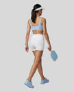 Woman wearing Athlesi CourtClub Tennis Short in White full-body back view showing high-rise fit