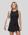 Woman wearing the Athlesi CourtClub Tie-Front Dress in Black, mid-body front view highlighting the asymmetric tie detail.