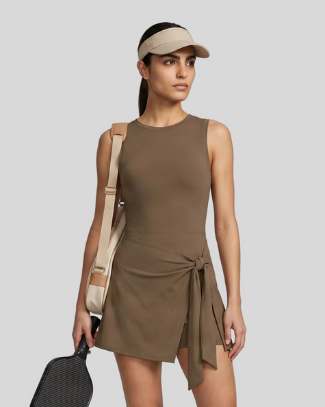 Woman wearing the Athlesi CourtClub Tie-Front Dress in Coffee, mid-body front view highlighting the asymmetric tie detail.