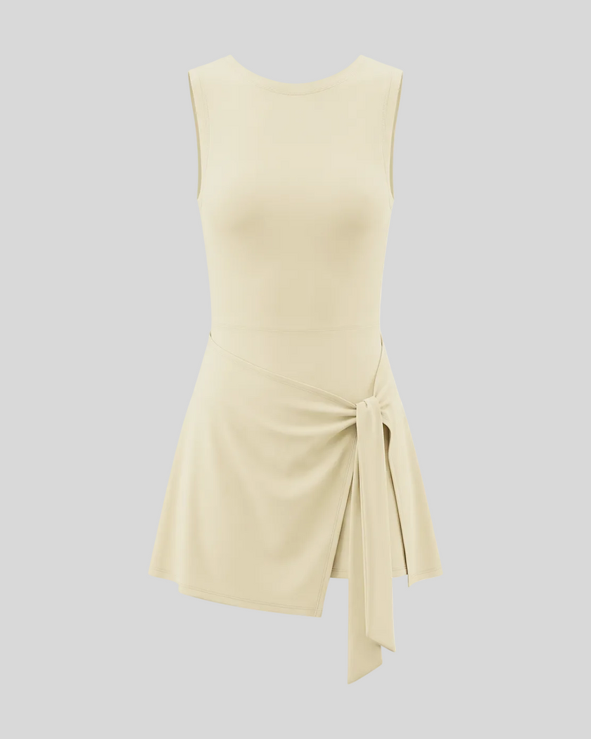 Athlesi CourtClub Tie-Front Dress in Light Apricot, front view with asymmetric adjustable tie and flared skirt.