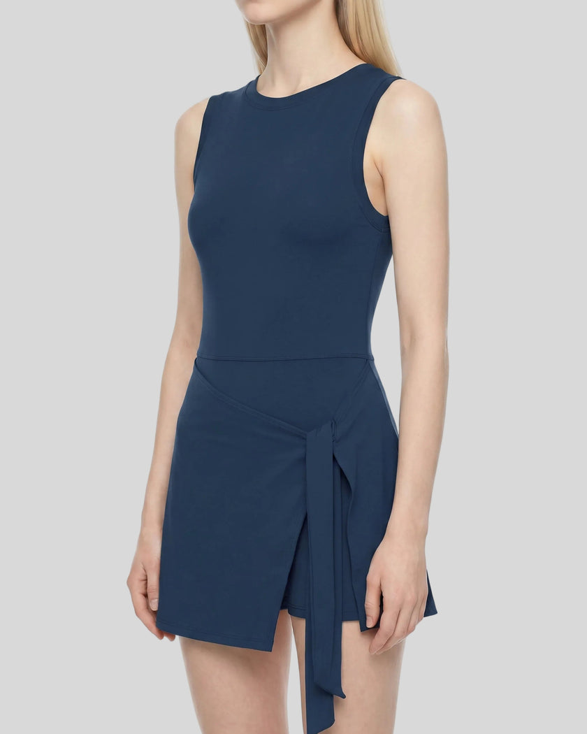Side angle view of Navy Blue CourtClub Tie-Front Dress with a wrap-style skirt and side tie detail, shown on a model against a plain white background.